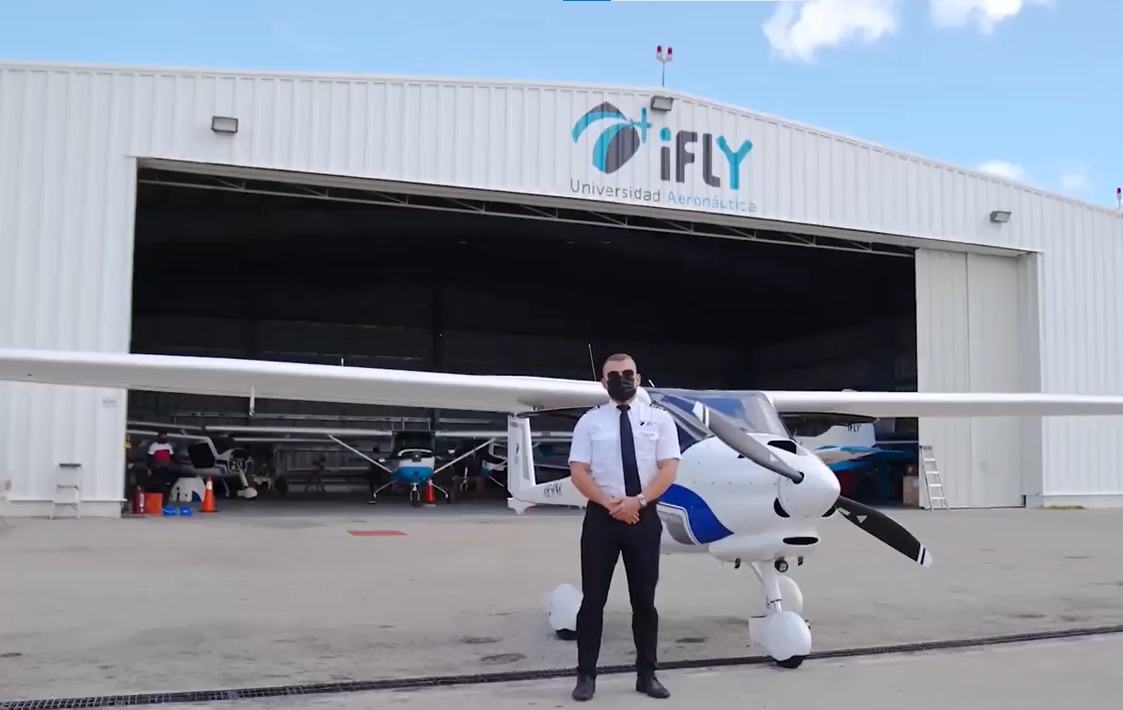 Pilot standing in front of plane at iFly hangar